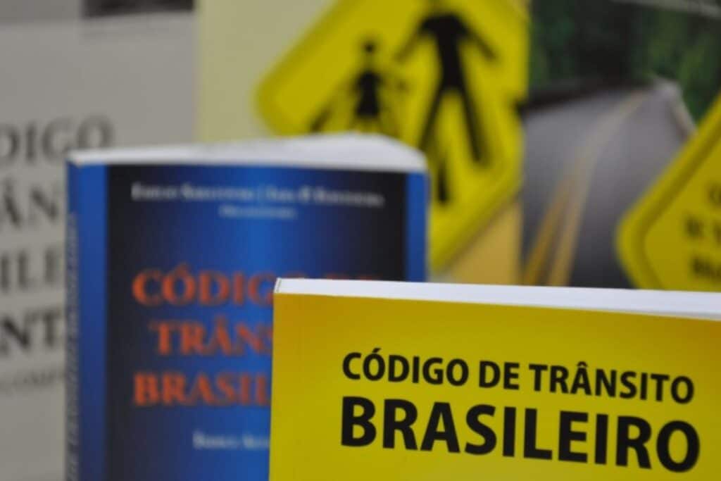 Livros Código de Trânsito Brasileiro, sinalização ao fundo.