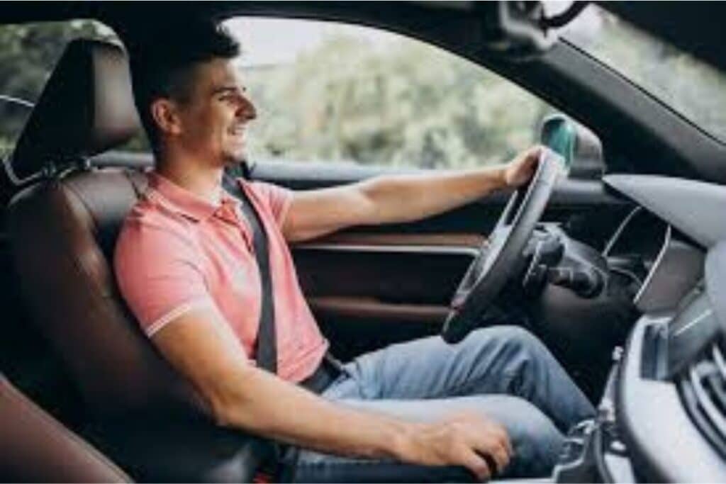 Homem sorrindo dirigindo carro.