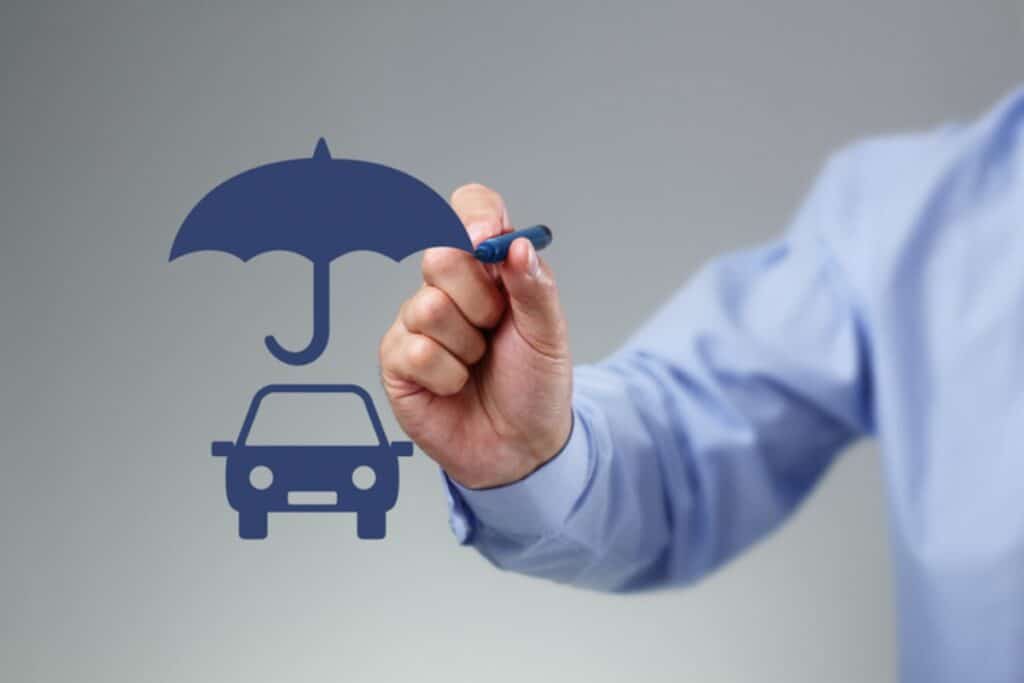 Homem desenha guarda-chuva protegendo carro.