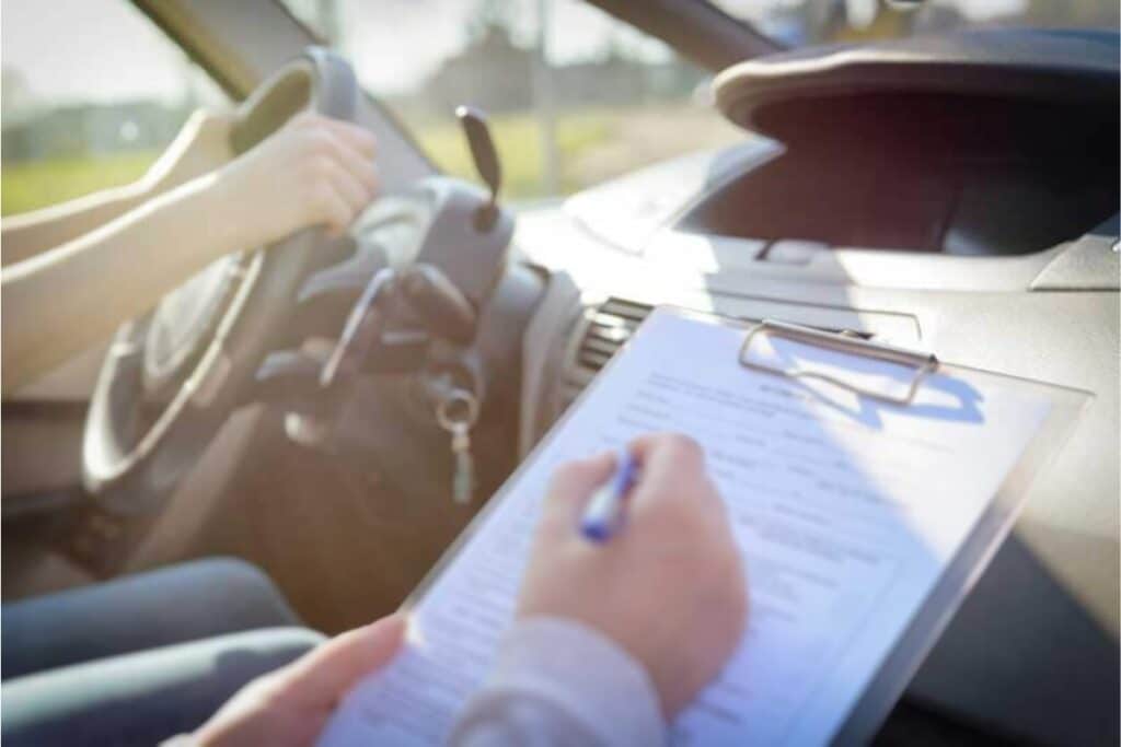 Pessoa dirigindo e assinando documentos no carro.